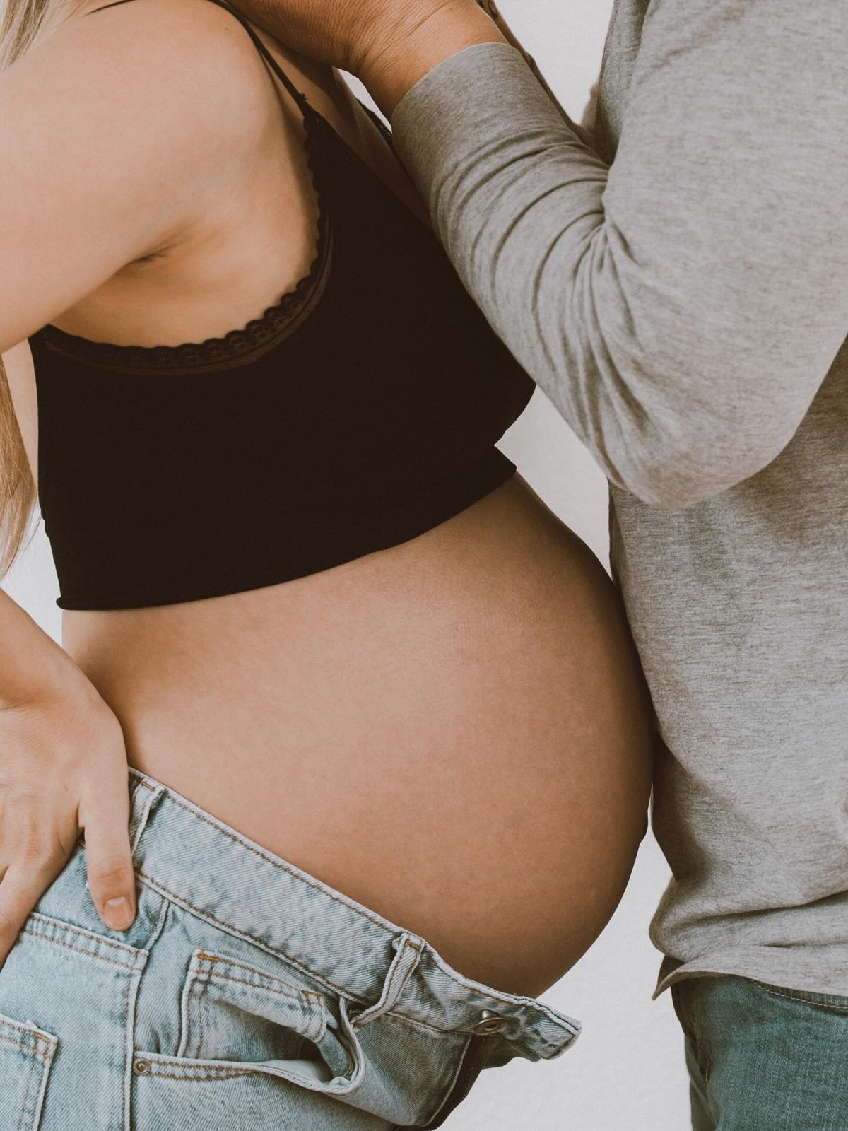 Nahaufnahme eines Babybauchs mit Händen