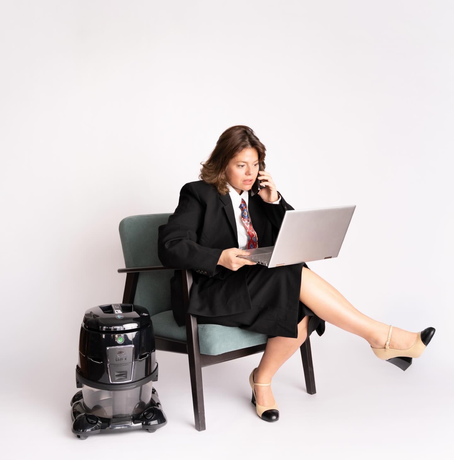 Frau im Anzug sitzt mit Laptop auf einem Sessel, Businessportrait